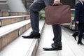 Business and grow up concept. Business man holding briefcase and walking up stairs going to work at morning in the city Royalty Free Stock Photo