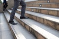 Business and grow up concept. Close up legs business man holding briefcase and walking up stairs going to work at morning in the