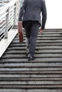 Business and grow up concept. Business man holding briefcase and walking up stairs going to work at morning in the city Royalty Free Stock Photo