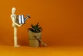 Business growth success process symbol. Wooden manequin, house plant from, miniature watering can. Beautiful orange background.