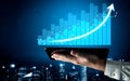 Business Growth Visualization with Tablet in Hand Displaying Digital Chart with Positive Trend and Urban Night Royalty Free Stock Photo