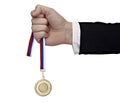 Business hand holding golden medal