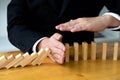 Business hand stops domino continuous overturned meaning that hindered business failure. Stop over this business failure concept Royalty Free Stock Photo