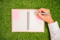 Business hand writing notebook on green grass Royalty Free Stock Photo