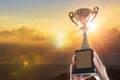 Business hands holding trophy cup on sky background. Royalty Free Stock Photo