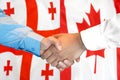 Handshake on Georgia and Canada flag background