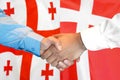 Handshake on Georgia and Denmark flag background