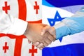 Handshake on Georgia and Israel flag background