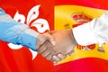 Handshake on Hong Kong and Spain flag background Royalty Free Stock Photo