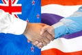 Handshake on New Zealand and Thailand flag background