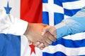 Handshake on Panama and Greece flag background