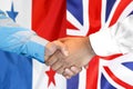 Handshake on Panama and UK flag background