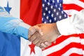 Handshake on Panama and USA flag background