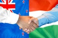 Handshake on New Zealand and Hungary flag background