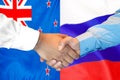 Handshake on New Zealand and Russia flag background