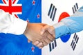 Handshake on New Zealand and South Korea flag background