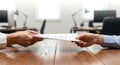 Business Handshake and Document Exchange in Office Setting Royalty Free Stock Photo