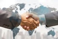 business handshake with global map blended into background Royalty Free Stock Photo