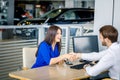 Sales manager and female customer shaking hands congratulating each other at the dealership showroom. Royalty Free Stock Photo