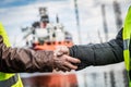 Business handshake in a shipyard. Shipbuilding industry