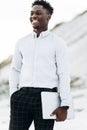 Business handsome african american man posing outdoors holding laptop, stylish black man on mountains background