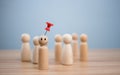 Business and human resources concept for leadership and team leader. A red pin pinned on one wooden doll stands apart and stands