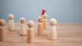 Business and human resources concept for leadership and team leader. A red pin pinned on one wooden doll stands apart and stands