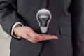 Business Idea Concept - Closeup of Lightbulb Over Business Woman's Hand