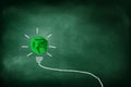 Green crumpled paper ball light bulb lighting grow around on chalkboard. Royalty Free Stock Photo