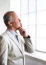 Business ideas forming in his mind. A thoughtful businessman looking out of his office window. Royalty Free Stock Photo