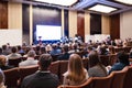 Business Ideas. Male Host Speaking In Front of the Group of Business People During a Conference