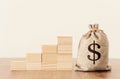 Business image of a sack with money over wooden desk