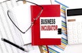 BUSINESS INCUBATOR text on notebook with chart, calculator and pen