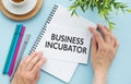 BUSINESS INCUBATOR text on notepad with pen, business