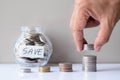 Business investment and finance accounting concept. Hand putting coin into stack step up growing growth with coins in glass bottle Royalty Free Stock Photo