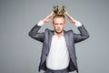 Business king. Confident businessman in crown standing isolated on gray Royalty Free Stock Photo