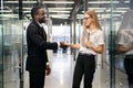 Lady boss handshaking with new african employee greeting each other. Multiracial business colleagues walking at office Royalty Free Stock Photo