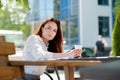 Business lady drinking coffee at a table on a summer terrace