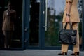 Business lady holding a laptop bag going to the office. Display of businesswoman on modern buildings in the city