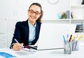 Business lady sitting at office desk with laptop