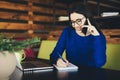 Business lady speak on phone and make notes at work table Royalty Free Stock Photo