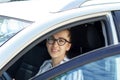 Business lady tears off the car holding a phone in his hand. Young attractive girl in a business style in a shirt and black pants Royalty Free Stock Photo