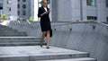 Business lady walking down stairs and texting on smartphone, careerist lifestyle Royalty Free Stock Photo