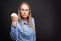 Business lady wearing blue glasses posing showing fist like fighting. Royalty Free Stock Photo
