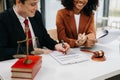 Business and lawyers discussing contract papers with brass scale on desk in office. Law, legal services, advice, justice and law Royalty Free Stock Photo