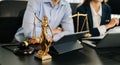 Business and lawyers discussing contract papers with brass scale on desk in office. Law, legal services, advice, justice and law Royalty Free Stock Photo