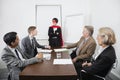 Business leader as superhero in front of colleagues at meeting in conference room Royalty Free Stock Photo