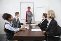 Business leader as superhero in front of colleagues at meeting in conference room Royalty Free Stock Photo