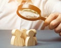 Business leader holding a magnifying glass over a team of workers. The concept of finding new employees. Teamliding. Team