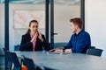 A business leader in a suit conversing with her worker in the IT industry about new business projects and existing